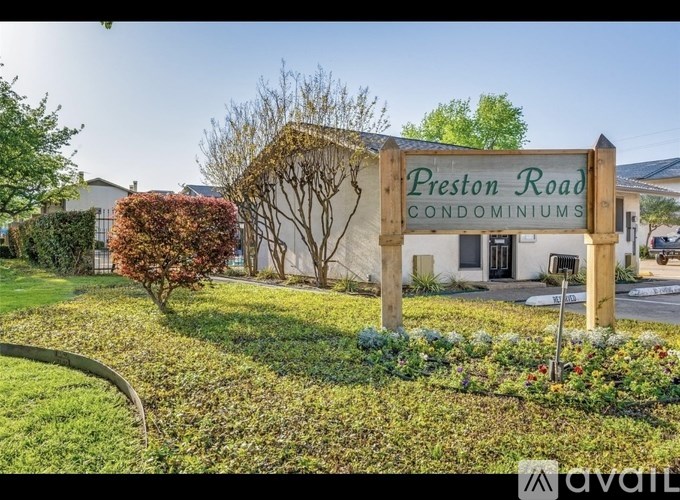 A sign for Preston Road Condominiums is in front of a building.