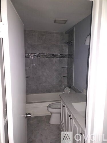 A bathroom with a toilet, sink, and shower.