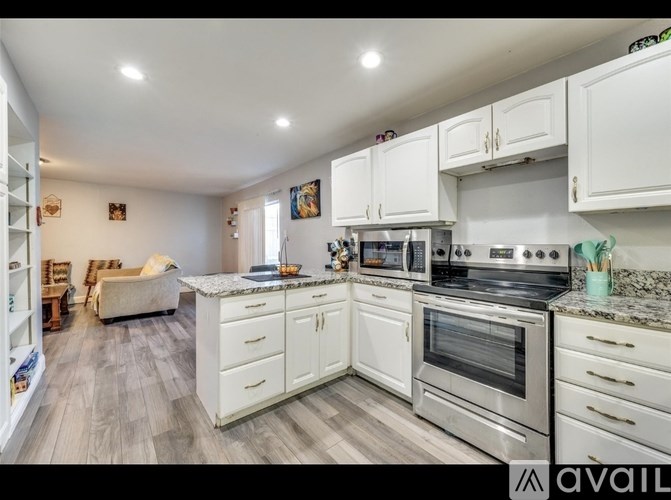 A kitchen with white cabinets and a stainless steel oven.