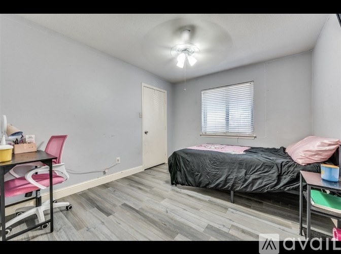A bedroom with a bed, desk, and chair.