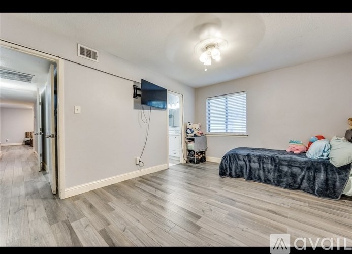 A bedroom with a bed, a TV, and a wheelchair.