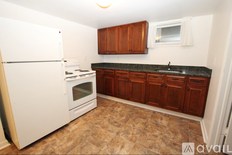 A kitchen with a white refrigerator and a black countertop.