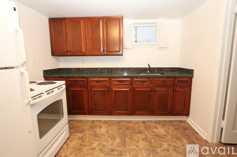 A kitchen with brown cabinets and a white stove.