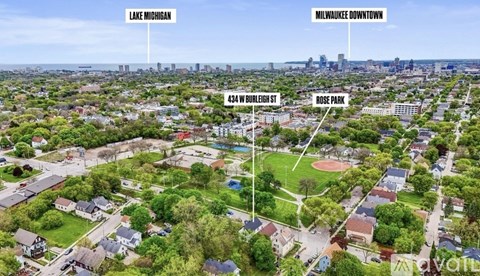 An aerial view of a neighborhood with Lake Michigan in the background and a baseball field in the foreground.