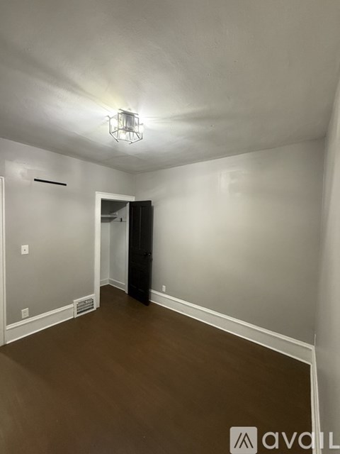 A room with a brown floor and white walls.