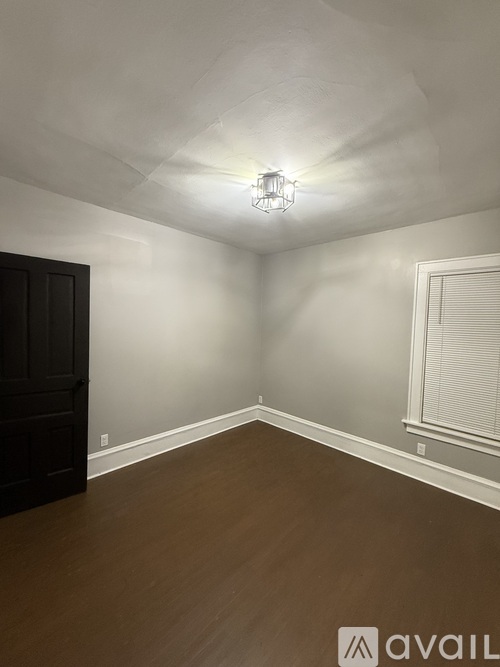 A room with a wooden floor and a light fixture on the ceiling.