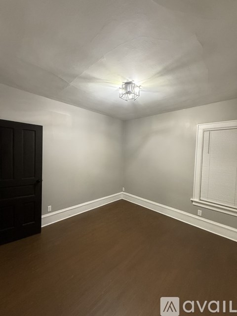 A room with a wooden floor and a light fixture on the ceiling.