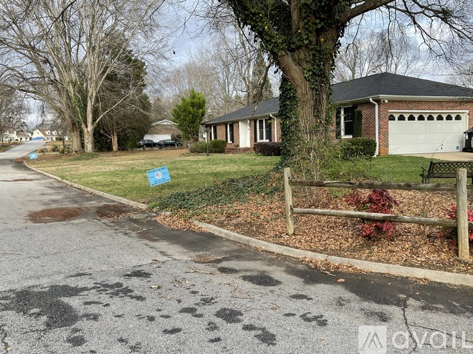 A blue sign is on the grass by the road.