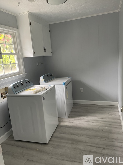 A white dishwasher and dryer are sitting in a kitchen.
