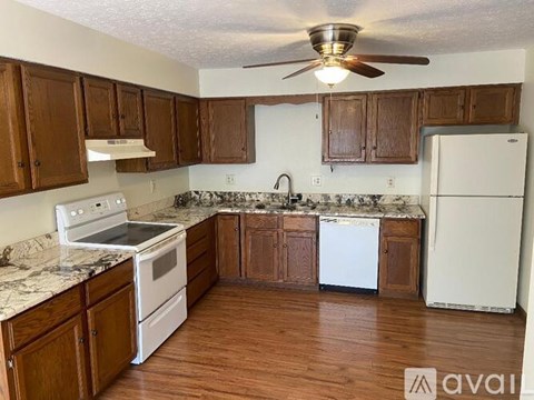 A kitchen with wooden cabinets and a white fridge.
