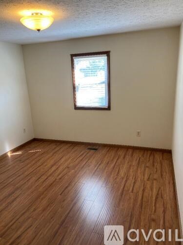 A room with wooden flooring and a window.