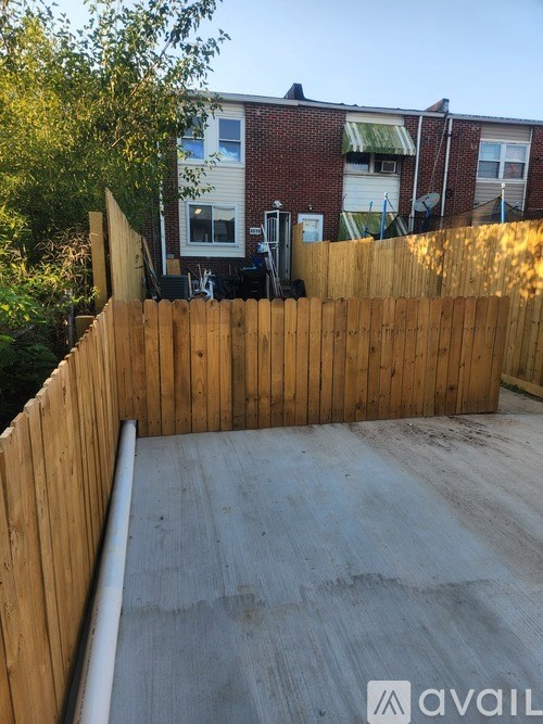 A wooden fence surrounds a concrete area.