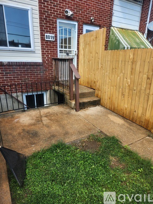 A backyard with a wooden fence and a small patio area.