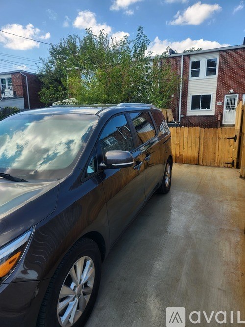 A black car is parked in a driveway.