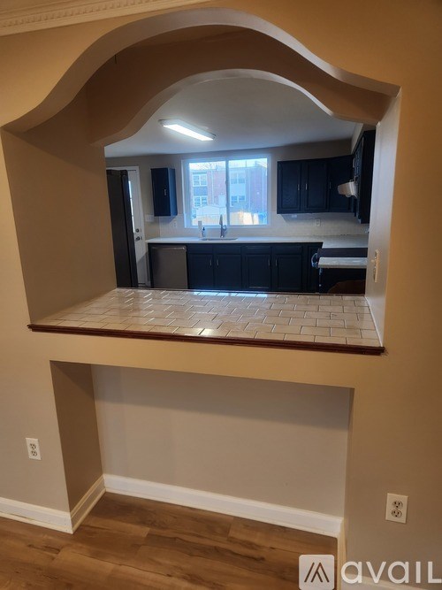 A kitchen with black cabinets and a window.