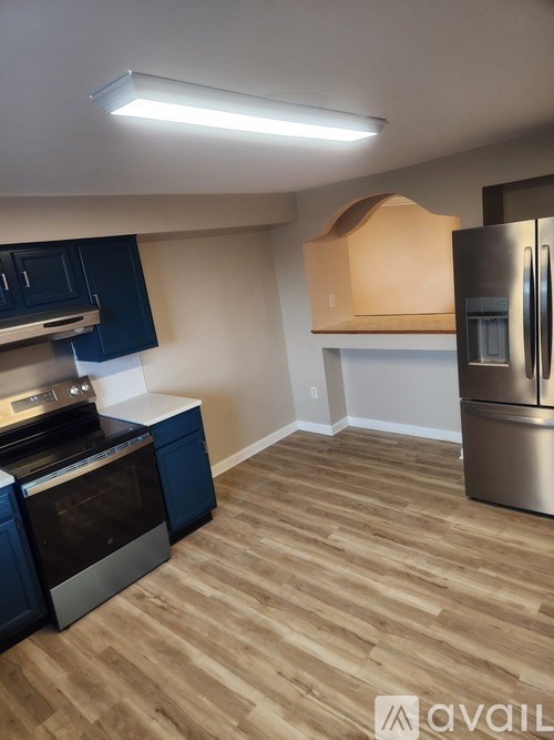 A kitchen with a stove top oven and a refrigerator.