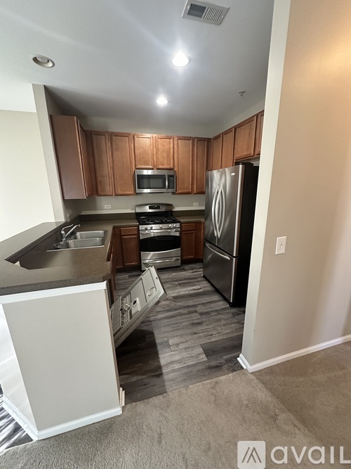 A kitchen with wooden cabinets and a black refrigerator.