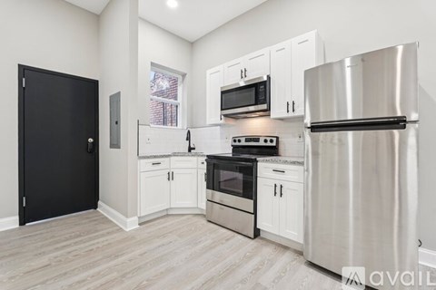 A kitchen with white cabinets and stainless steel appliances.