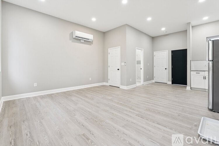 A spacious room with a refrigerator on the right side.