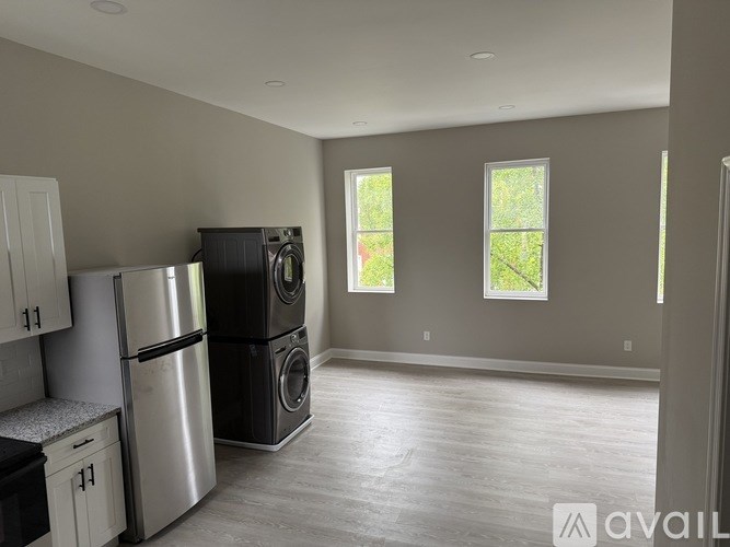 A kitchen with a refrigerator, dishwasher, and washing machine.