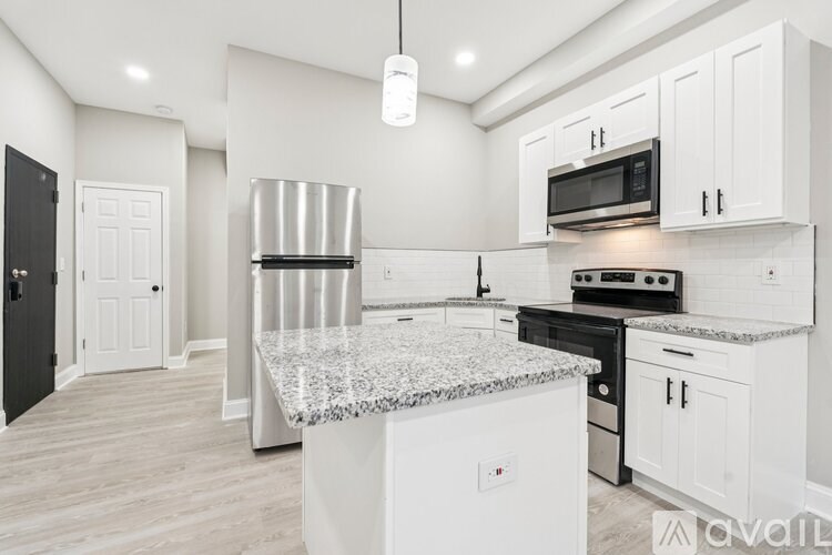 A kitchen with white cabinets and a granite countertop.