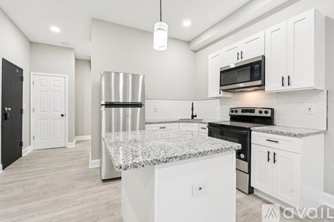A kitchen with white cabinets and a granite countertop.