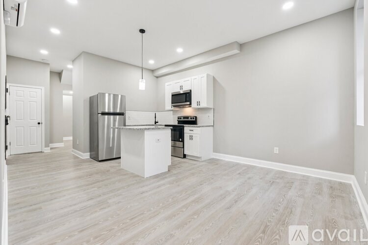 A kitchen with white cabinets and a wooden floor.