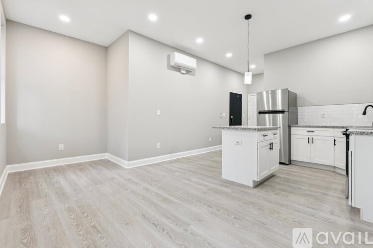 A kitchen with white cabinets and a wooden floor.