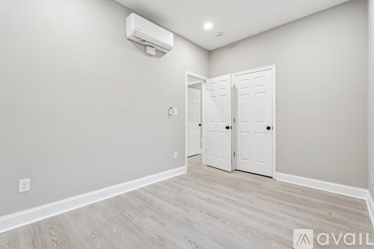 A room with a white door and a wall-mounted air conditioner.