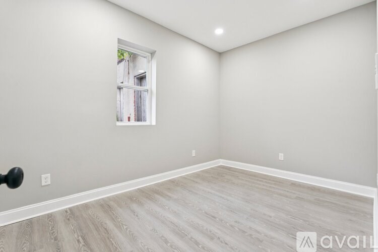 A room with a window and wooden flooring.