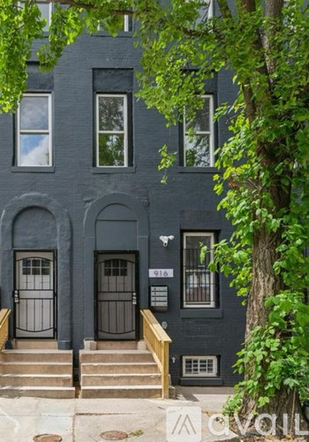 A black building with a tree in front of it.