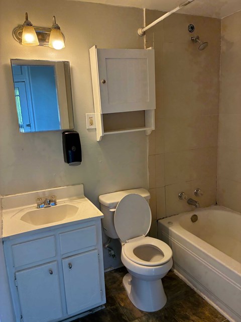 A white bathroom with a toilet, sink, and bathtub.