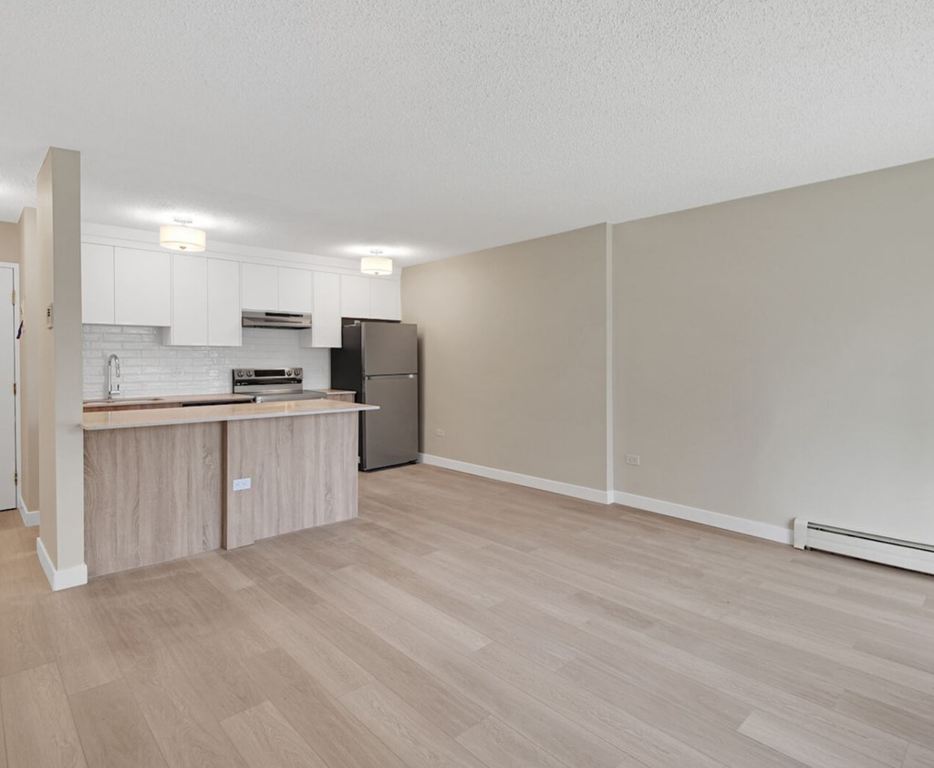 A kitchen with a refrigerator, oven, and sink.