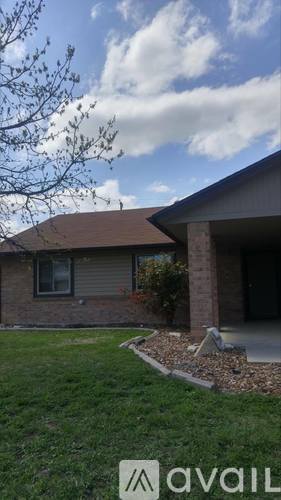 A house with a brown roof and a tree in front of it.