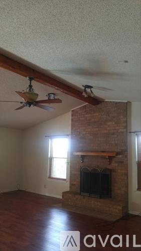 A living room with a fireplace and a ceiling fan.