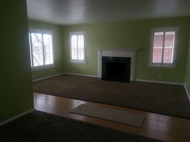 A room with a fireplace and two windows.