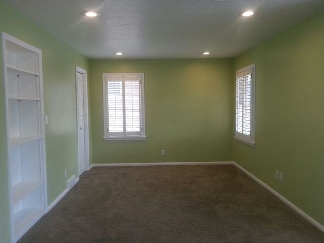 A room with green walls and brown carpet.