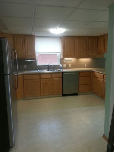 A kitchen with wooden cabinets and a refrigerator.