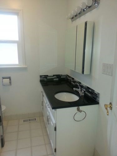 A bathroom with a sink and a mirror.