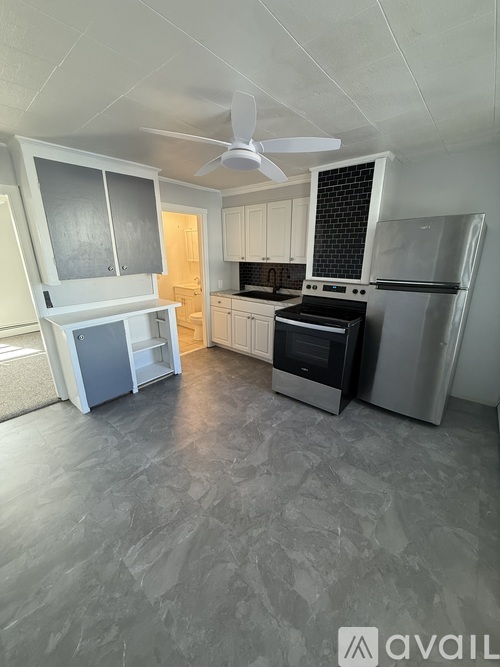 A kitchen with a refrigerator, oven, and microwave.