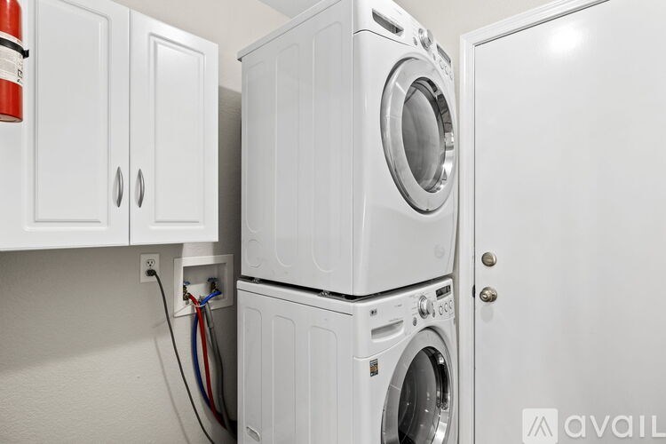A stack of white washing machines in a laundry room.