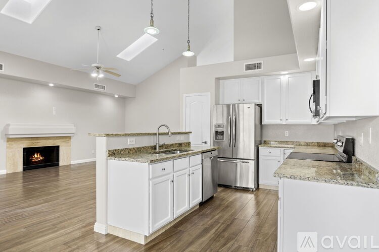A modern kitchen with white cabinets and a fireplace.