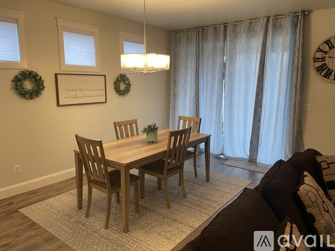 A dining room with a wooden table and chairs.