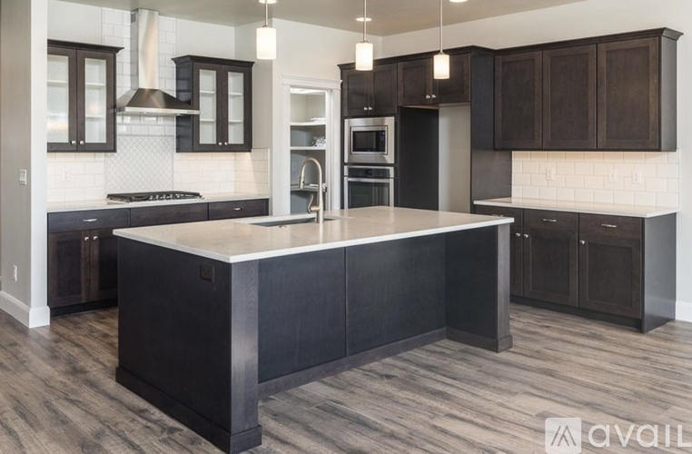 A modern kitchen with dark wood cabinets and a large island.