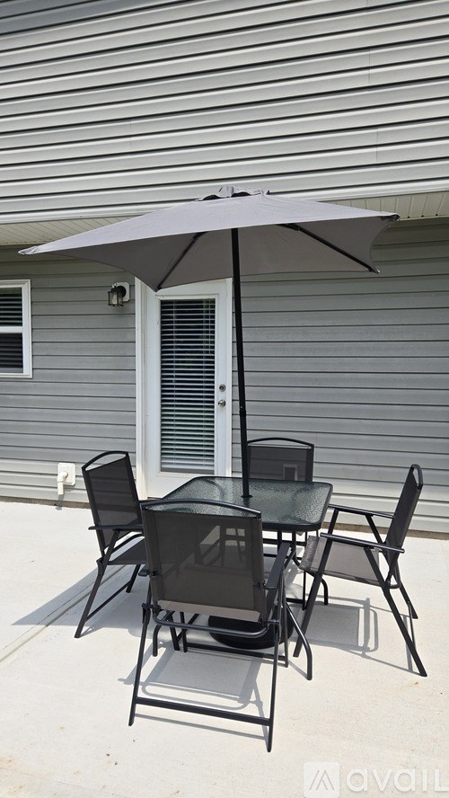 A patio table set with chairs and an umbrella.