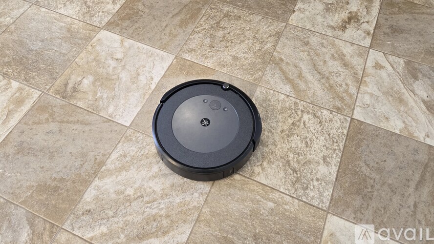 A robotic vacuum cleaner on a tiled floor.