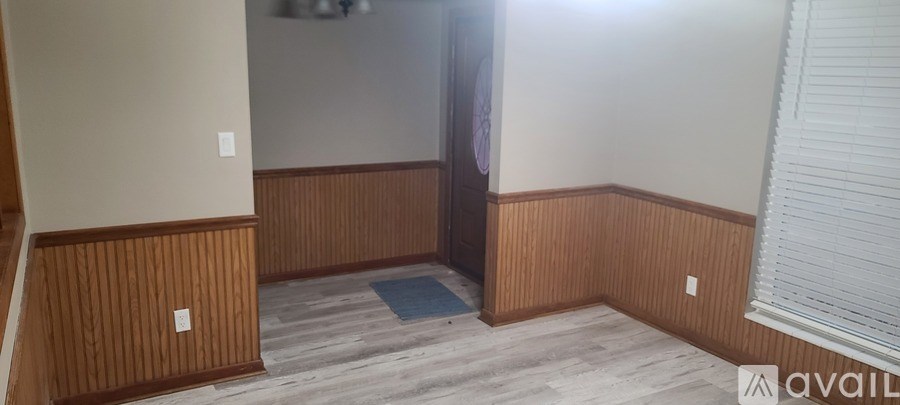 A room with wooden paneling on the walls and a blue rug on the floor.