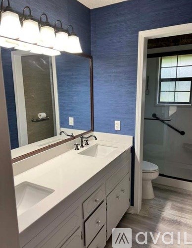 A bathroom with blue walls and a white sink vanity.