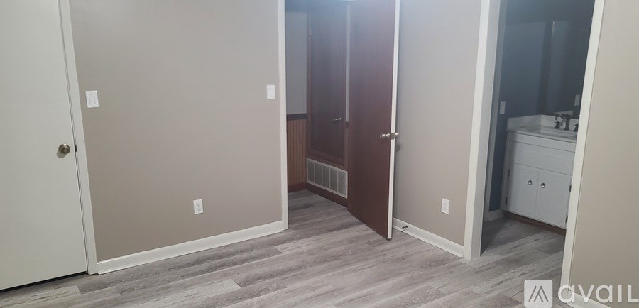 A bathroom with a white vanity and a wooden door.