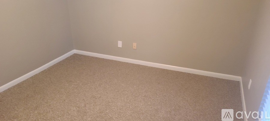 A room with beige carpet and white walls.
